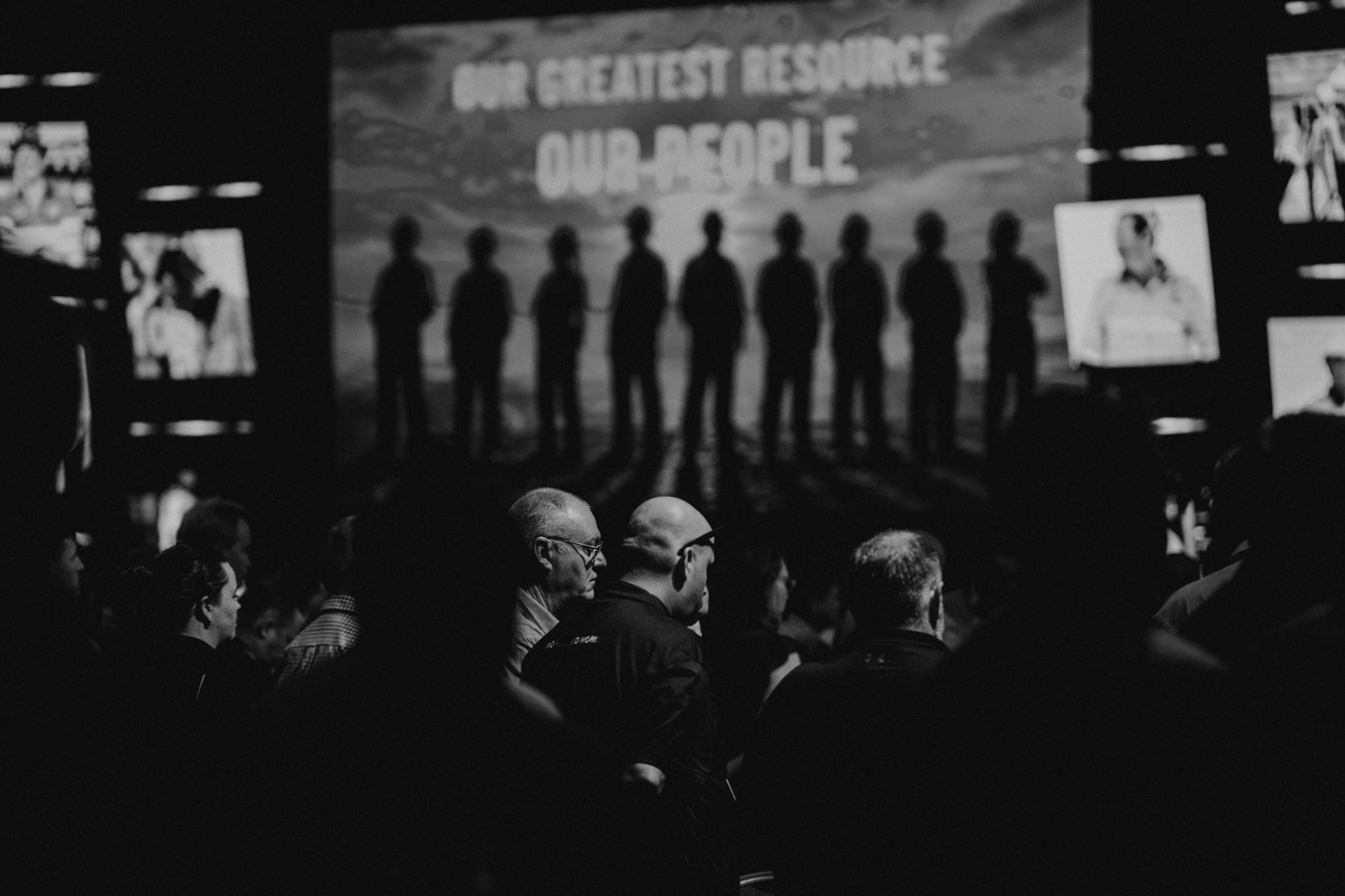 Delegates at a Queensland mining industry health and safety conference in front of a screen reading Our greatest resource, our people